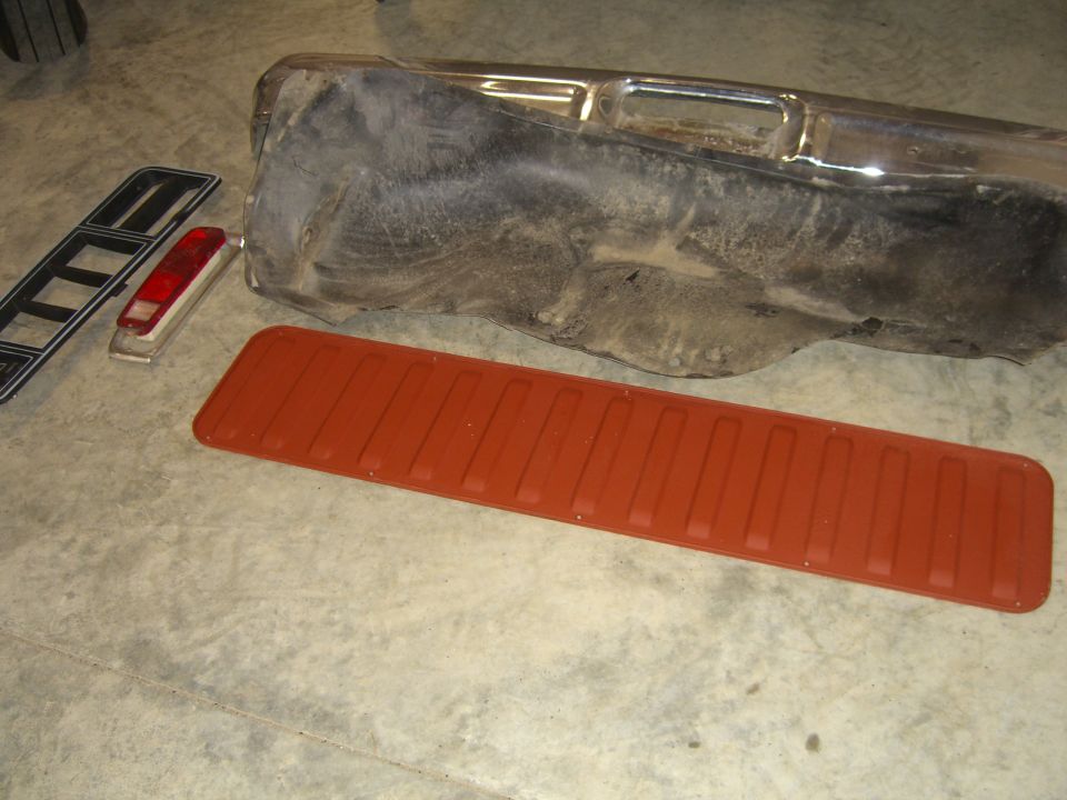 Chrome bumper, red tailgate trim, and black taillight bezel on concrete floor