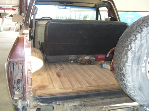 1979 Ford Bronco - Rear view of a 1979 Ford Bronco showing the cargo area, rear seat, and spare tire.