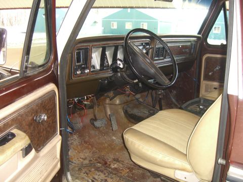 1979 Ford Bronco - The interior of a 1979 Ford Bronco shows tan seats and a brown dashboard with visible wiring.