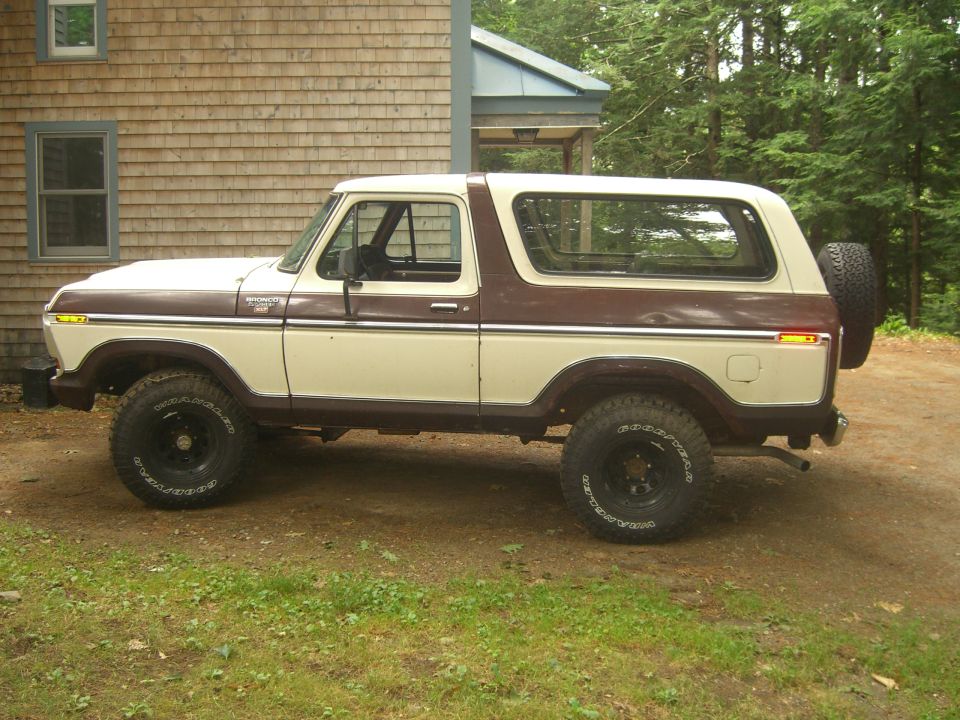 Side view of a 1979 Ford Bronco, two-tone brown and cream, with a spare tire mounted on the rear