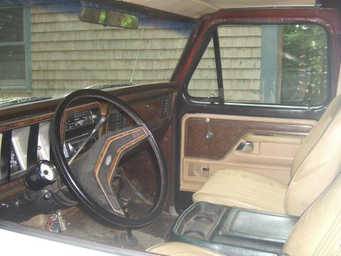 1979 Ford Bronco - The interior of a 1978 Ford Bronco is visible, with wood-grain trim and tan upholstery.