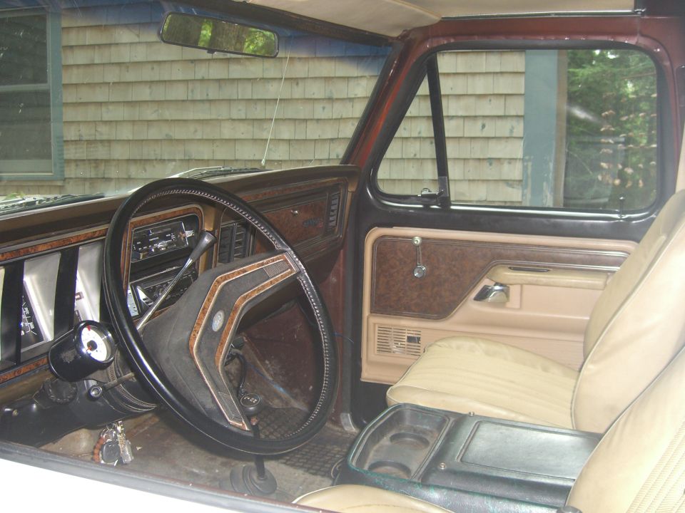 Interior of a 1978 Ford Bronco showing the dashboard, steering wheel, and tan seats