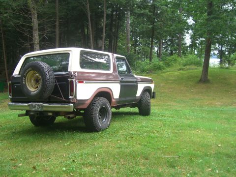 1979 Ford Bronco - A two-tone brown and white 1978 Ford Bronco sits on a grassy area with trees in the background.