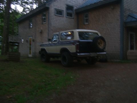 1979 Ford Bronco - A 1978 Ford Bronco is seen from the rear, parked beside a house with a well in the yard.