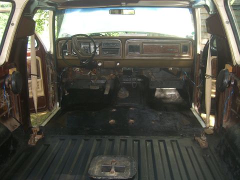 1979 Ford Bronco - The interior of a 1979 Ford Bronco is shown with the carpet and some interior panels removed, revealing the floor and wiring.