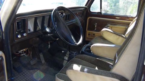 1979 Ford Bronco - The interior of a vehicle features a dashboard, steering wheel, and upholstered seats.