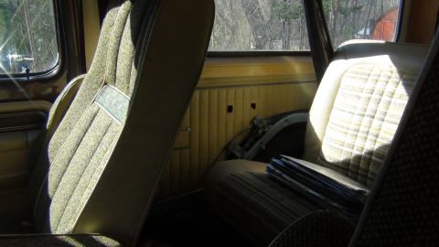1979 Ford Bronco - The interior of a 1979 Ford Bronco shows its distinctive patterned cloth seats and ribbed paneling.