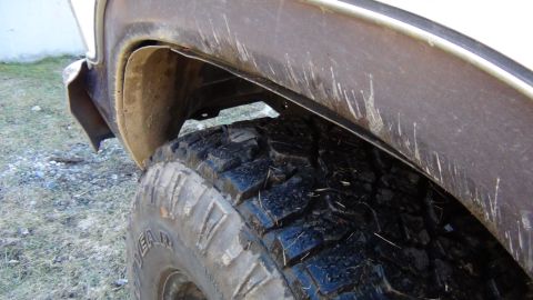 1979 Ford Bronco - Muddy tire and wheel well detail on an off-road vehicle. Supermotors.net logo is present.
