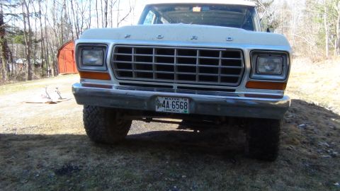 1979 Ford Bronco - The front grille and headlights of a 1979 Ford Bronco are visible in this outdoor shot.