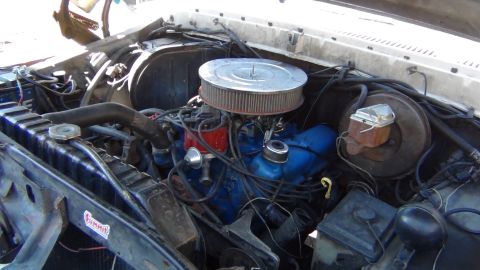 1979 Ford Bronco - Close-up view of the engine bay, a blue engine block, air filter, and radiator.