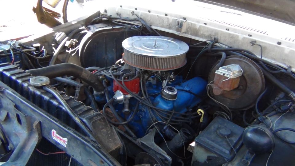 Engine bay with blue engine block, air filter, and radiator
