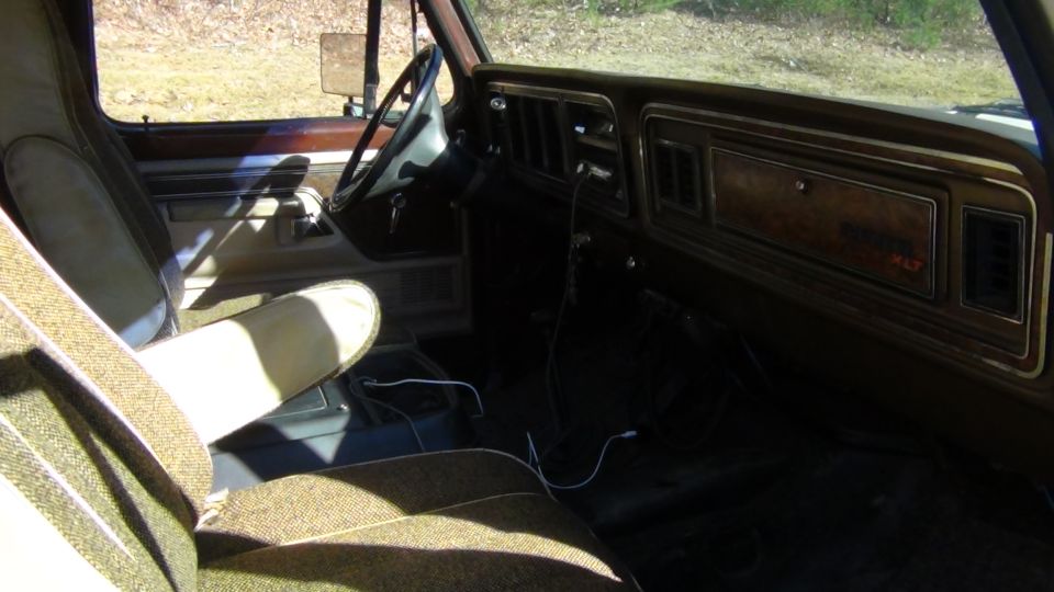 Interior of a 1979 Ford Bronco showing patterned seats and wood-grain dashboard