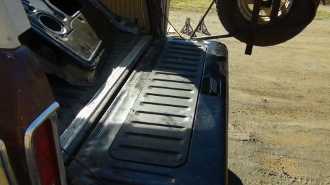 1979 Ford Bronco - The interior cargo space of a vehicle is shown, with a spare tire visible overhead.