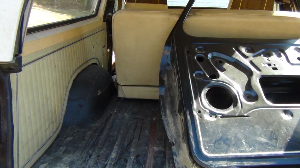 1979 Ford Bronco interior showing rear seat, side panel, and removed door frame