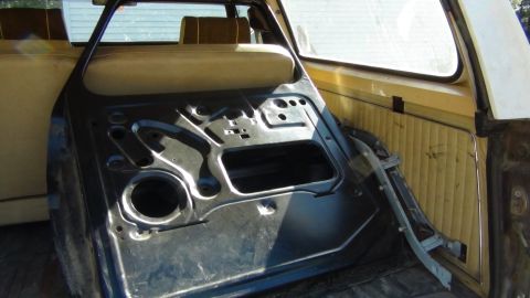 1979 Ford Bronco - The interior of a vehicle door, revealing its internal structure and some of the surrounding cabin.