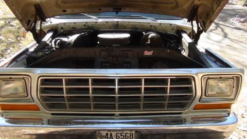 1979 Ford Bronco - The front grille and engine bay of a 1979 Ford Bronco are visible with the hood raised.