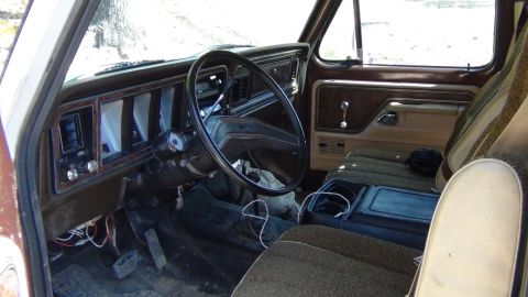 1979 Ford Bronco - The interior of a truck is shown, the dashboard, steering wheel, and seats.