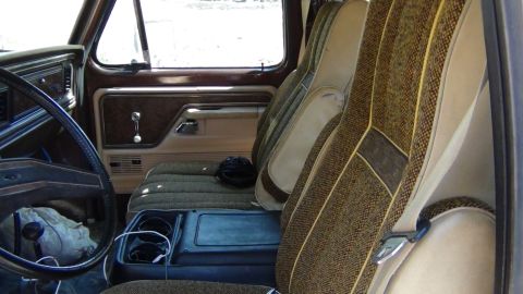1979 Ford Bronco - The interior of this 1979 Ford Bronco features distinctive patterned upholstery and wood-grain accents on the door panels.