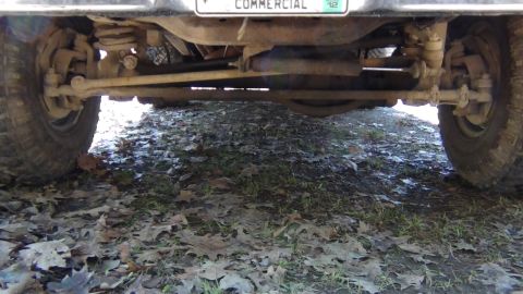 1979 Ford Bronco - A low-angle shot shows the undercarriage and rear tire of a vehicle, with a license plate visible above.
