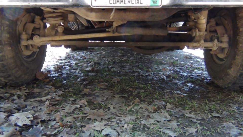 Undercarriage view of a vehicle's rear axle and tire