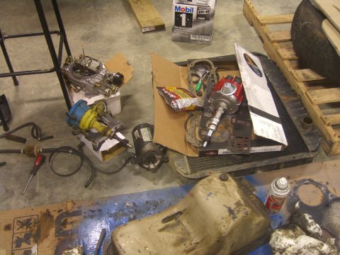 1979 Ford Bronco - Various automotive parts are laid out on the floor, suggesting a repair or restoration project.