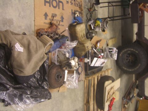 1979 Ford Bronco - A cluttered garage scene with a tire and various parts visible.