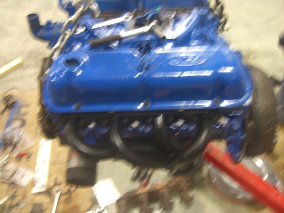 Blue Ford engine with tools on workbench