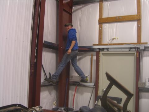 1979 Ford Bronco - A person navigates through a workshop area with industrial shelving and equipment.