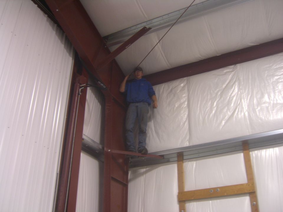 Man on beam inside metal building