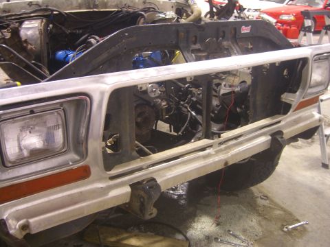 1979 Ford Bronco - Front end of a 1979 Ford Bronco undergoing repairs, engine compartment visible.
