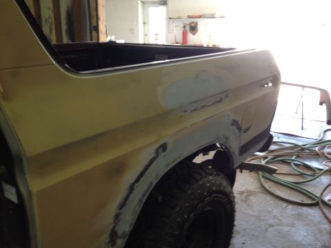 1979 Ford Bronco - Rear quarter panel of a yellow 1979 Ford Bronco undergoing bodywork in a shop.