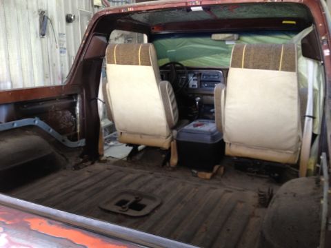 1979 Ford Bronco - The interior of a 1979 Ford Bronco shows its tan and brown striped seats and the dashboard.