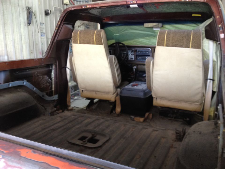 Interior view of a 1979 Ford Bronco with tan and brown striped seats