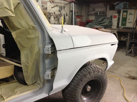 1979 Ford Bronco - A vehicle is undergoing bodywork in a garage, with parts masked off for painting.