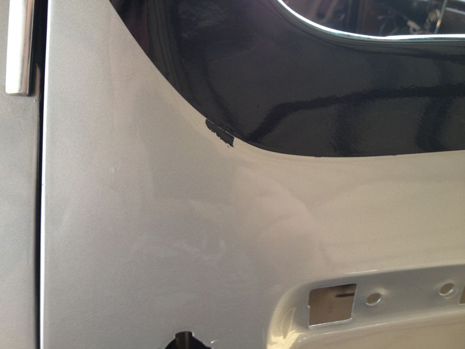 Close-up of a silver vehicle body panel with a black trim piece and a Supermotors.net watermark