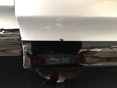 1979 Ford Bronco - Close-up of a vehicle's lower body panel shows a two-tone paint scheme and reflective trim.