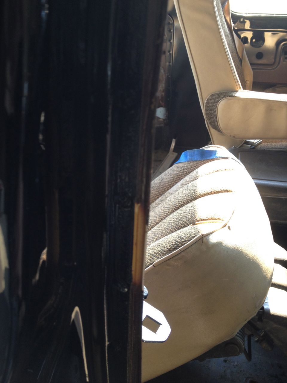 Interior view of a vehicle seat with patterned fabric and a blue tape accent