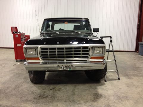 1979 Ford Bronco - A black 1979 Ford Bronco is shown from the front in a garage setting.