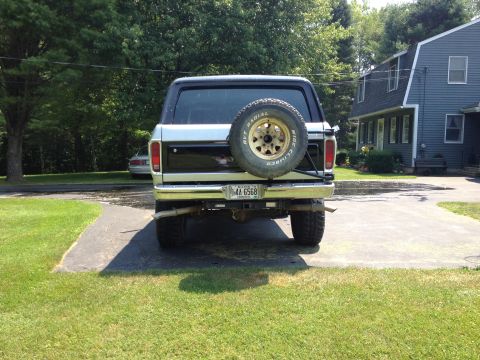 1979 Ford Bronco - The rear of a Ford Bronco is parked in a driveway next to a house.