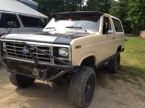 1979 Ford Bronco - This Ford Bronco has a custom bumper and off-road tires. A second vehicle is parked nearby.