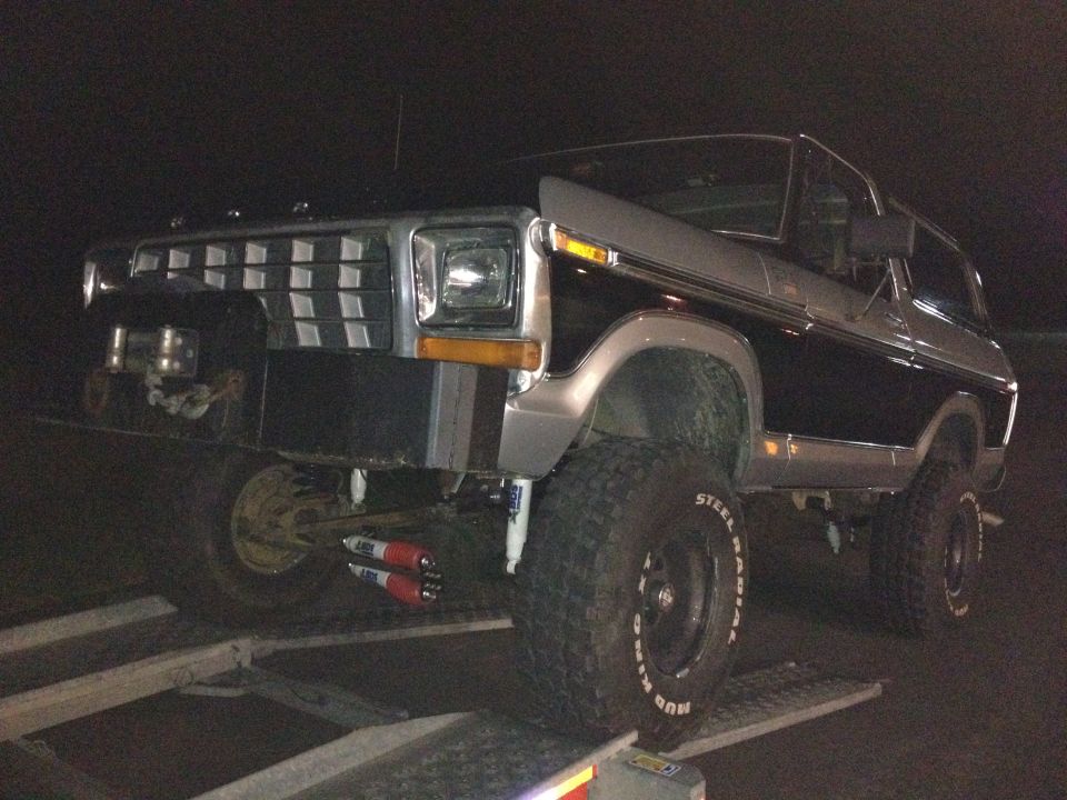 Ford Bronco on a trailer, front end visible. It has a chrome grille and large tires