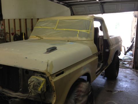 1979 Ford Bronco - A yellow Ford Bronco is masked and prepped for painting inside a garage.