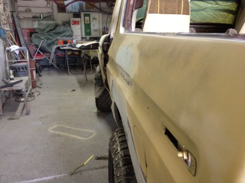1979 Ford Bronco - The vehicle is in a garage, possibly undergoing repairs or restoration, with tools and equipment visible in the background.