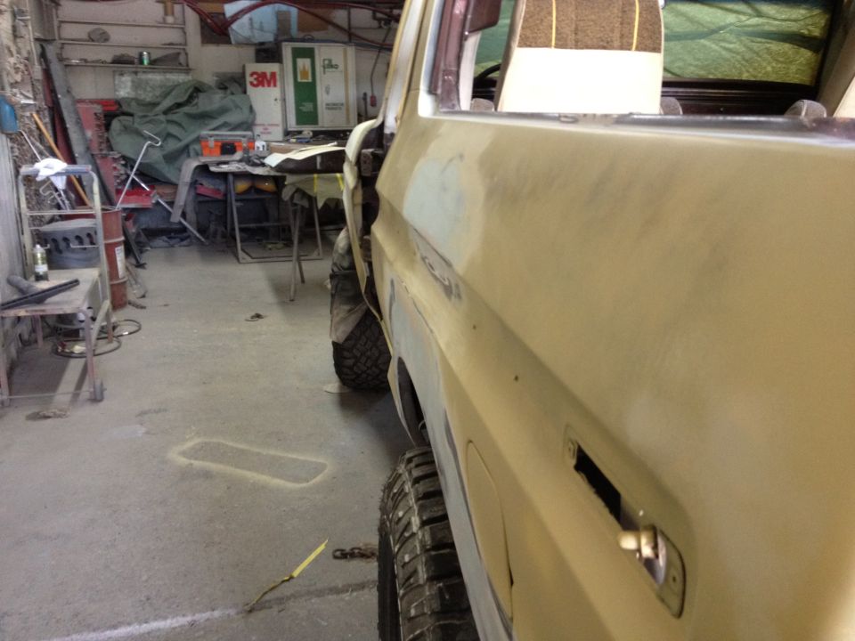 Side view of a 1979 Ford Bronco being worked on in a garage