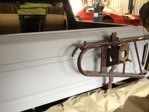 1979 Ford Bronco - The interior of a vehicle is shown, tan seats and an exterior-mounted spare tire carrier. Another vehicle is visible in the background.