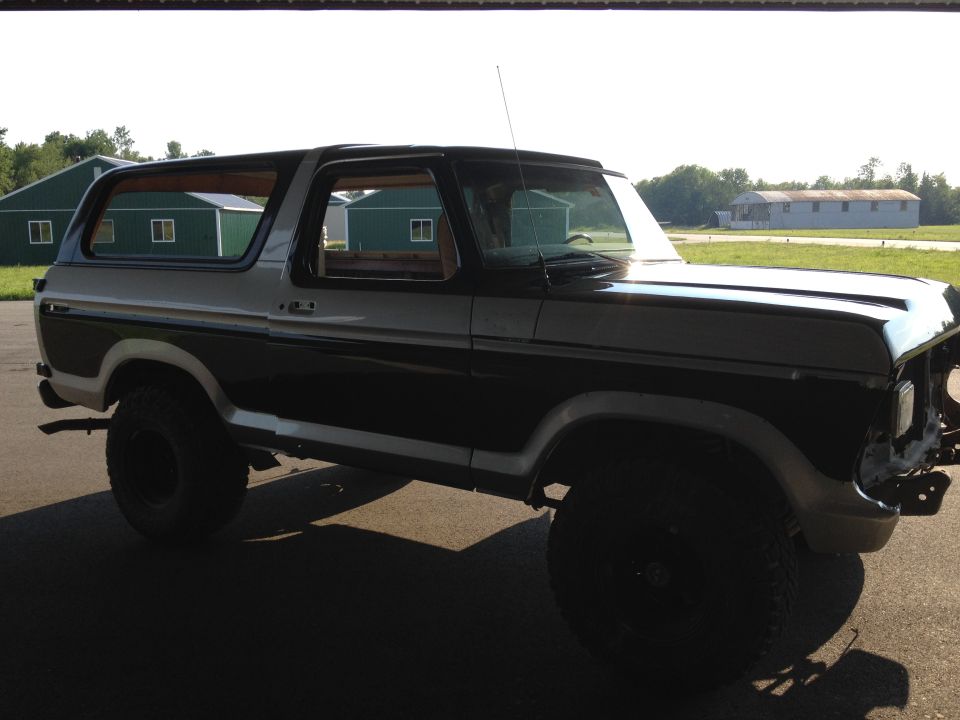 Ford Bronco with black and silver two-tone paint, lifted suspension, and missing front grille