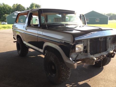 1979 Ford Bronco - This two-tone Ford Bronco is missing its grille and bumper, showing the radiator and frame underneath.