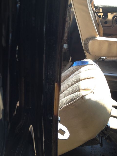 1979 Ford Bronco - Interior view of a vehicle, showing tan patterned seats and the door frame.