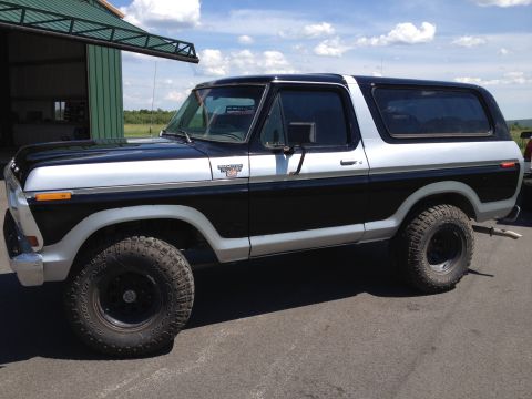 1979 Ford Bronco - This two-tone 1979 Ford Bronco features a black lower body and silver upper body, complemented by off-road tires.