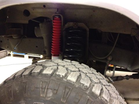 1979 Ford Bronco - This image shows a close-up view of a vehicle's suspension system, including a tire and shock absorber.